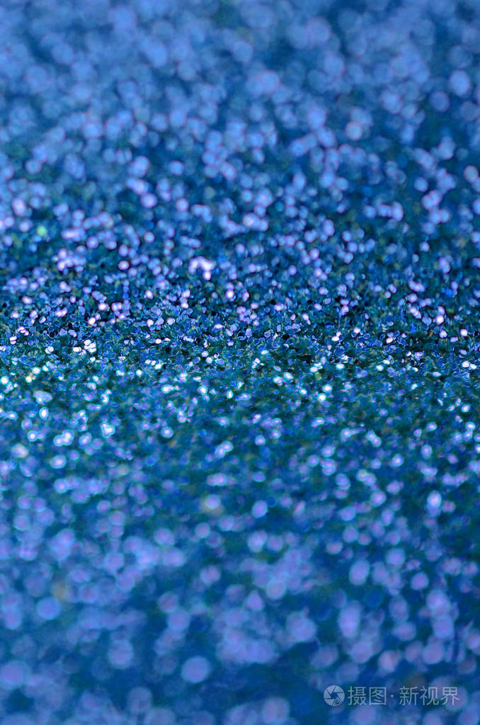 蓝色装饰亮片背景图像中有来自小元素的闪亮的bokeh光