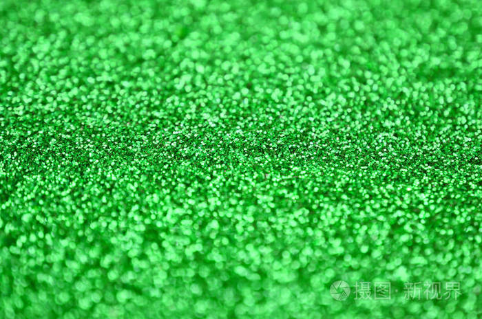 大量的绿色装饰亮片背景图像中有来自小元素的闪亮的bokeh光