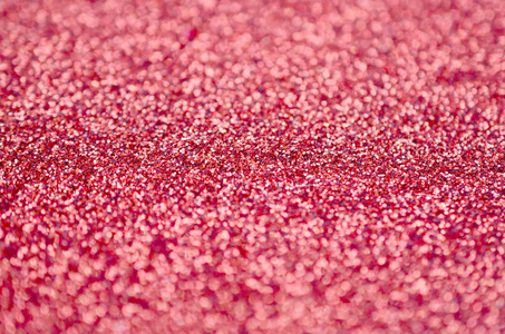 珊瑚红装饰亮片.背景图像中有来自小元素的闪亮的bokeh光照片