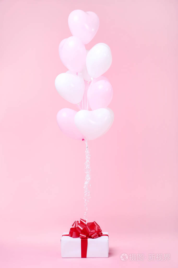 粉色背景上有礼品盒的心形气球