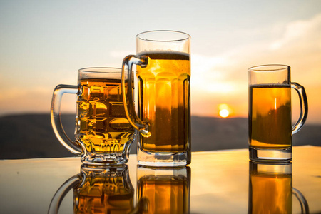 凉爽的夏季饮料概念.以阳光为背景的一杯生啤酒的特写镜头照片