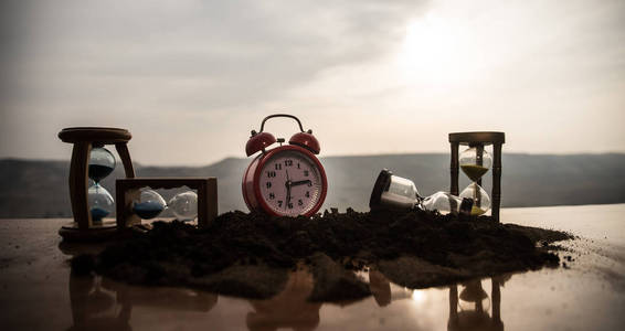 一个沙漏在明亮的蓝色天空前面,浮肿的白云掠过.时间概念.照片