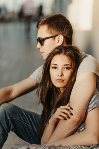 大街上情侣依偎一对快乐的恋爱中的年轻情侣,穿着休闲的年轻朋友们坐