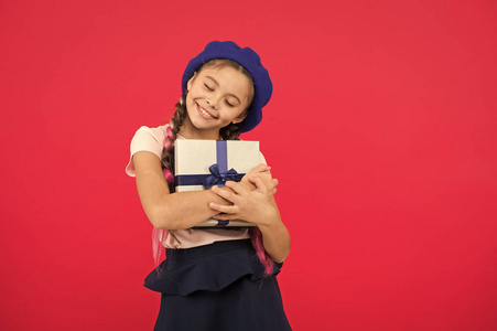 孩子对打开礼物的包装很兴奋.小女孩拿着红底丝带礼品盒.