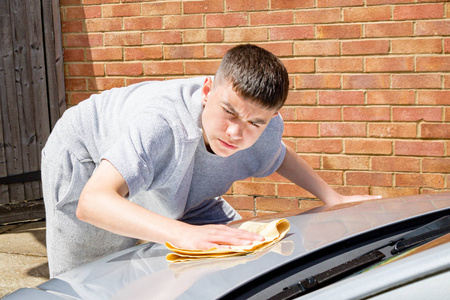 清洗和修理货车洗等大的作品穿着制服的年轻帅哥在洗车站用高压水洗车