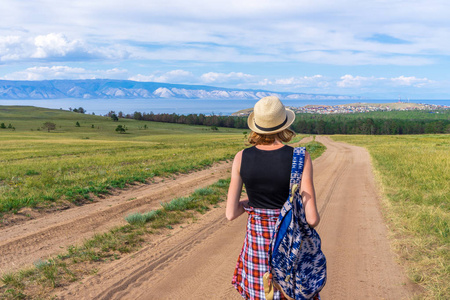 两名年轻男子在一辆带背包和头盔的旅游自行车上骑自行车旅行在乡间