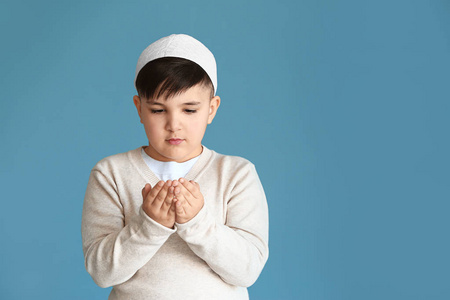 科阿拉兹穆斯林小男孩在彩色背景下祈祷照片