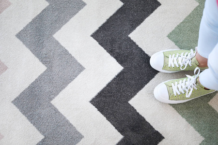 站在软地毯上的女人的腿,俯视图照片