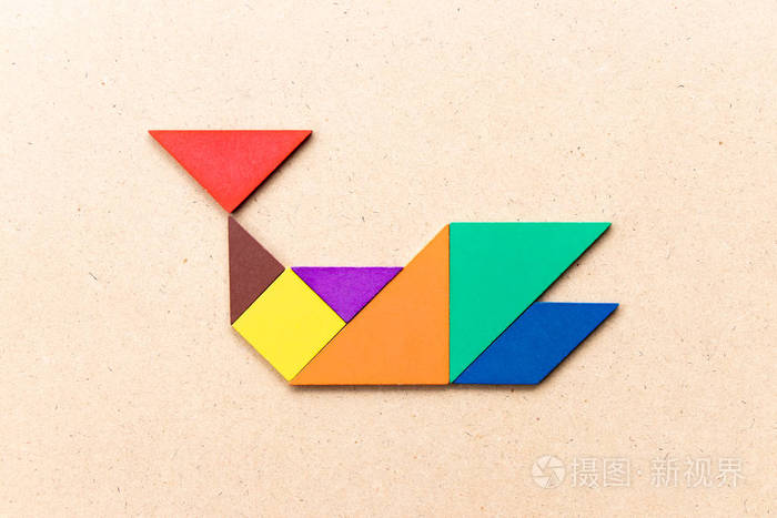 木头背景上鲸鱼形状的七巧板