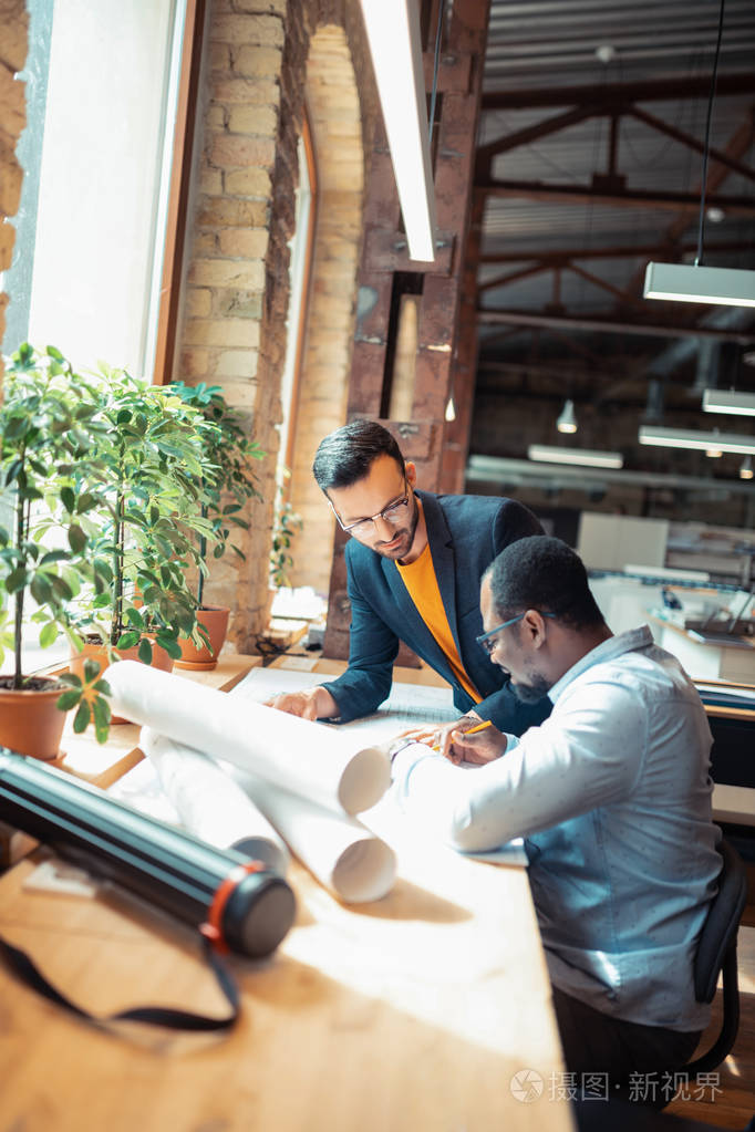 两位室内设计师坐在窗边画草图