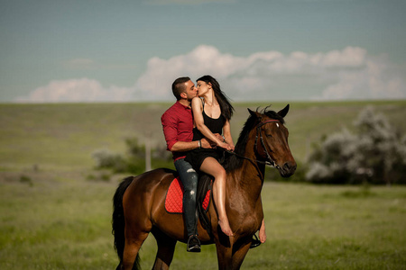 一对年轻夫妇骑马接吻.照片