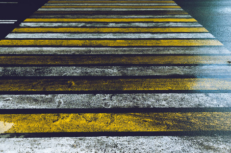 湿滑的道路,行人过街处涂上黄白相间的斑马线,雨后闪闪发光.照片