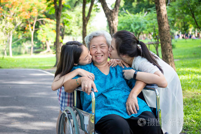 亚裔女儿和孙女在夏日户外公园亲吻面带微笑的老奶奶