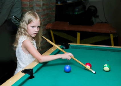 俄罗斯台球一个金发碧眼的小女孩在儿童俱乐部学习台球台球斯诺克