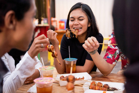 年轻人一起在户外美食城吃午饭图片