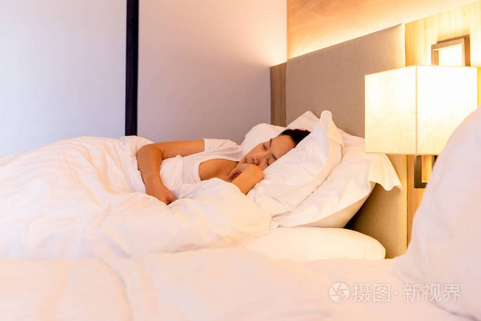 美丽的女人睡在床上柔软的白色枕头