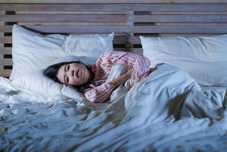 日本床上写真照年轻美丽,疲倦多病的亚裔日本妇女躺在家里病倒在床上