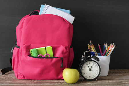 桌子书包返校概念,学习用品,书包和文具放在黑板上的木桌上照片