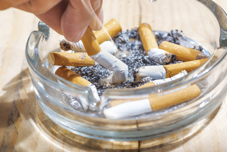 掐灭用手在透明烟灰缸里掐灭香烟照片