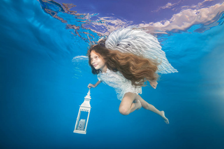 水下手电筒水下拿着手电筒的白色天使.水下女孩图片照片