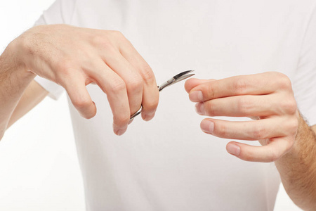 男人在白色背景上剪指甲照片