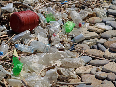 石头滩上的脏塑料瓶和垃圾.环境污染照片