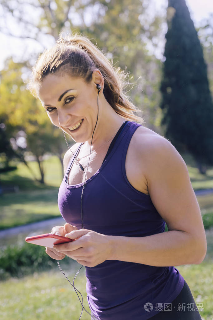 女运动员在跑步前听音乐