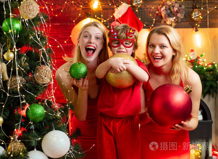 圣诞晚会女人们穿着红色的裙子庆祝圣诞节和可爱的小宝宝家庭纽带爱