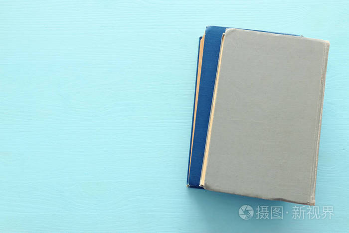 教育和返校理念蓝色木背景上的一摞书俯视图平放