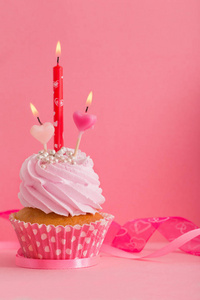 粉红色背景蜡烛纸杯蛋糕图片