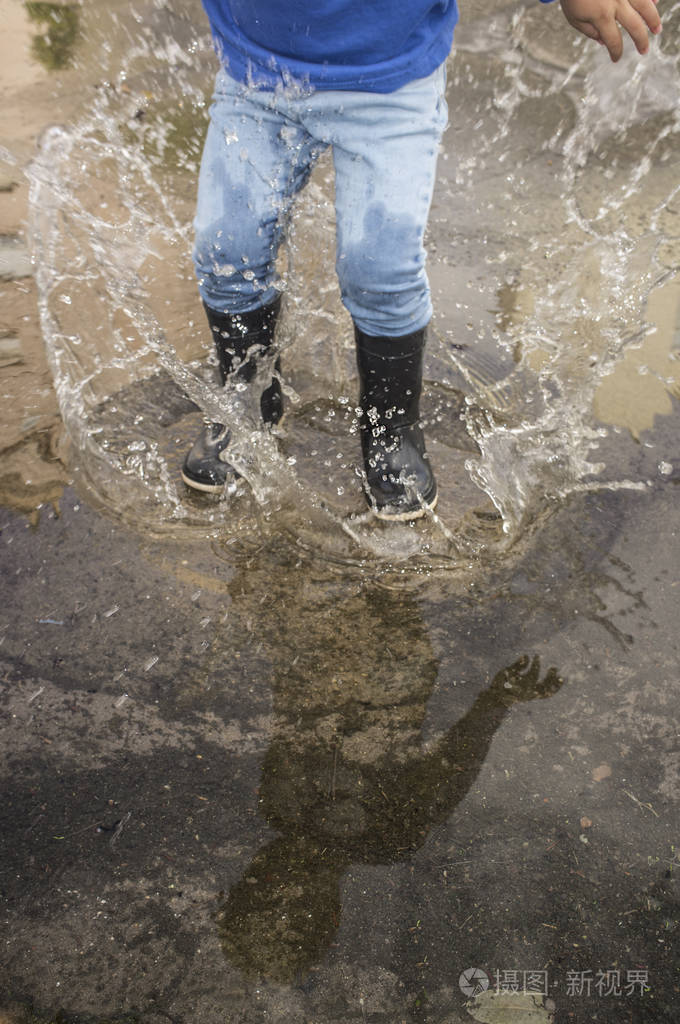三岁男孩在城市水坑玩