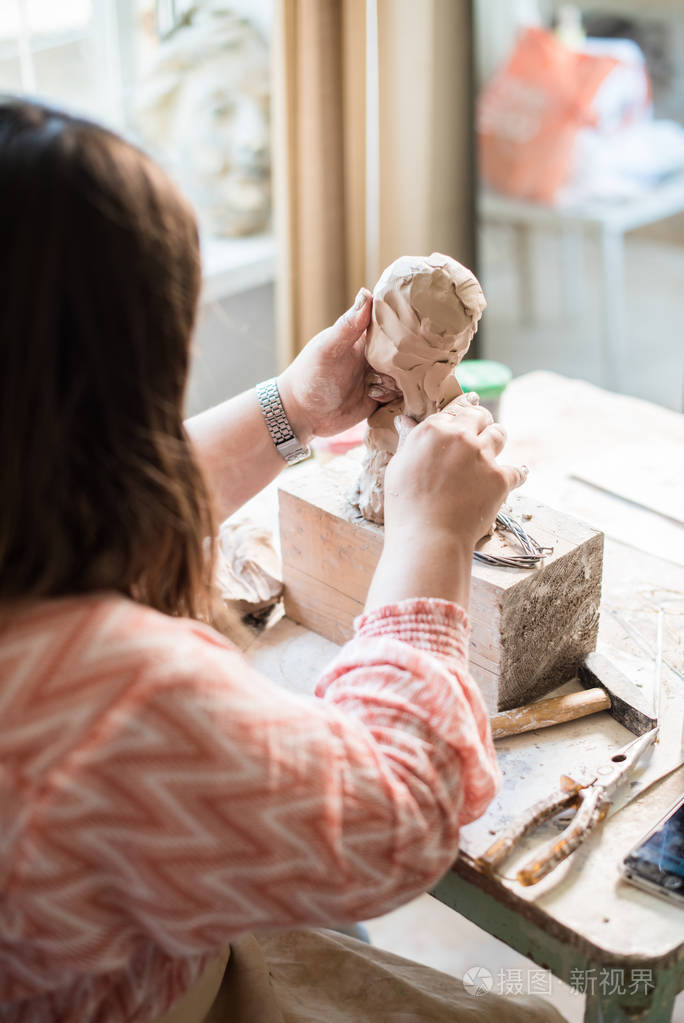 女雕塑家在她的工作室工作塞拉米斯艺术家的手
