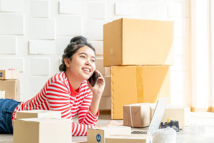 亚洲女企业主在家工作包装盒在w