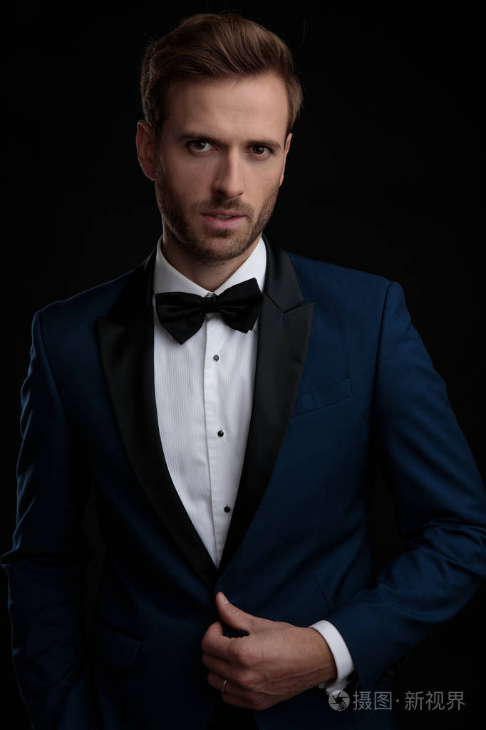 有动力的新郎解开蓝色燕尾服的纽扣照片-正版商用图片2l8bpo-摄图新视