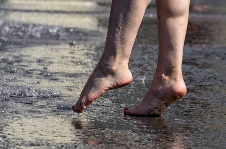 在雨中赤脚走过水坑.照片