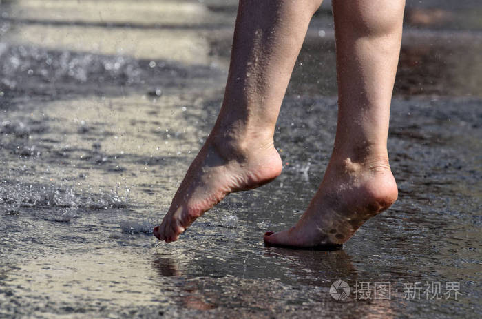 在雨中赤脚走过水坑