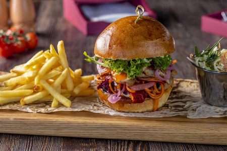 法国风格肉美味的新鲜汉堡,鸡肉,酱汁和薯条放在木板上,乡村风格,快餐