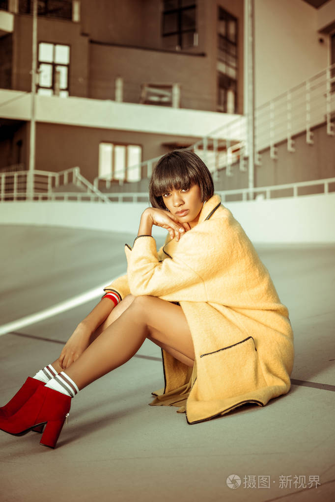 漂亮的深色皮肤模特坐在半位置