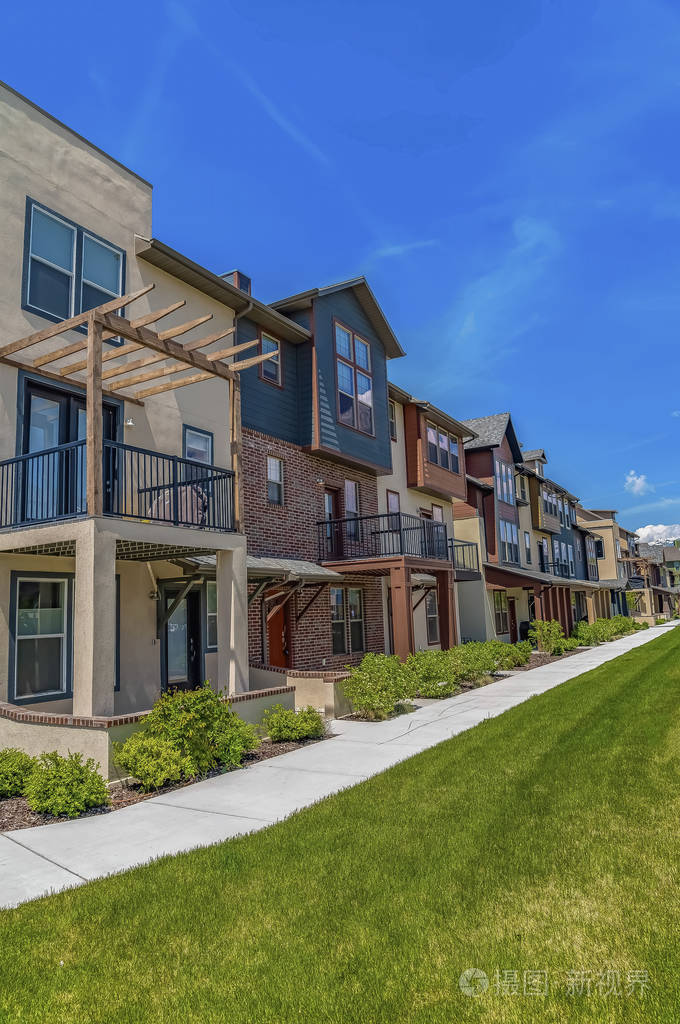 阳光明媚的日子里一排排有门廊和小阳台的房子