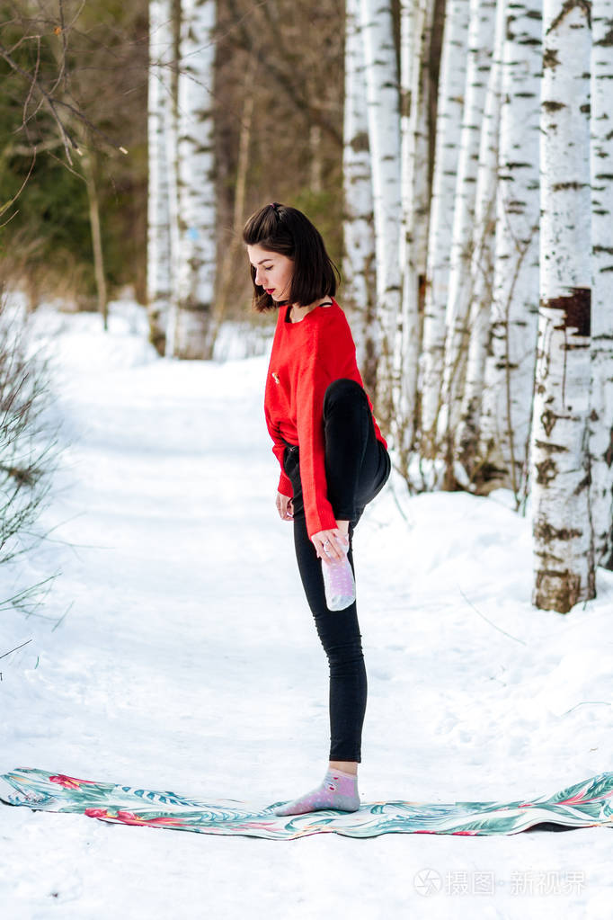 雪中瑜伽在公园里练习瑜伽的女孩每年的冬天白雪覆盖的树木