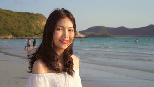 傍晚日落时分,美丽的女性在海边的沙滩上漫步,心情舒畅.