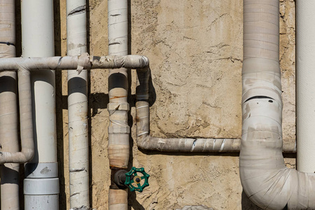 混凝土墙上的室外旧水管.照片