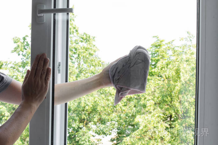 男工人手拿抹布擦窗户