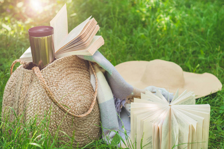 鸡保温在阳光明媚的夏日,草袋,书,帽子和保温杯照片