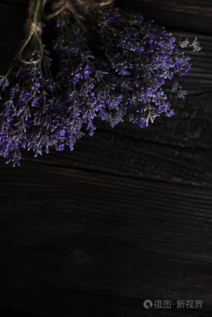 一束田野紫罗兰芬芳的薰衣草花在木质的深色背景上