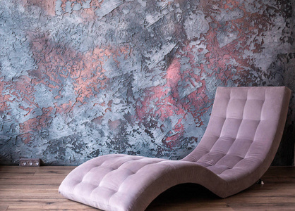 时髦的紫色躺椅靠在水泥墙上图片