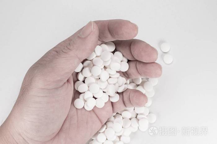 自杀药片药片过量用药的死者手中的药片白色背景的过量药丸的俯视特写