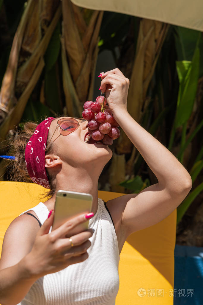 一个头戴红领巾的漂亮白人女孩吃葡萄的特写镜头