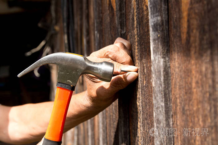 用锤子敲钉子老工人木匠