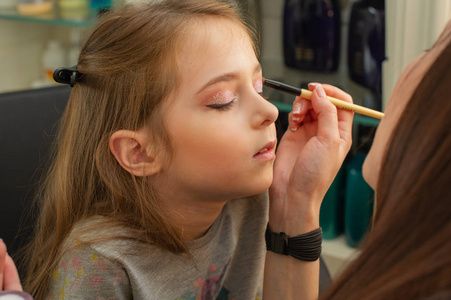 儿童概念在舞台上表演前化妆的小女孩.